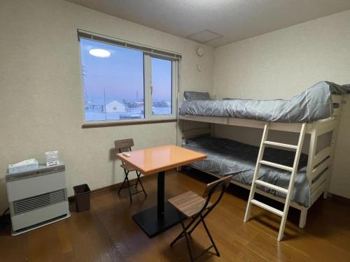 a room with a desk and a bunk bed and a table at TrainLineField in Tōbetsu