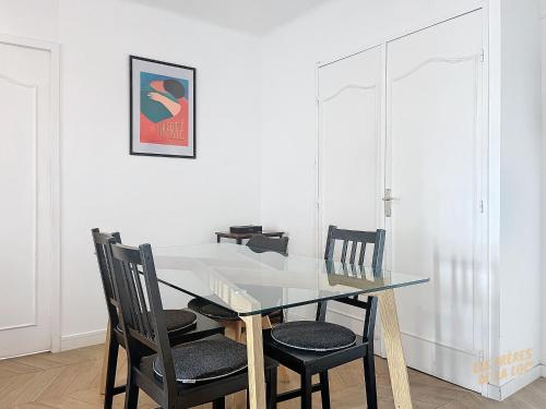 une salle à manger avec une table et des chaises en verre dans l'établissement Appartement avec Balcon - Vue sur Notre Dame - Les Frères de la Loc', à Marseille