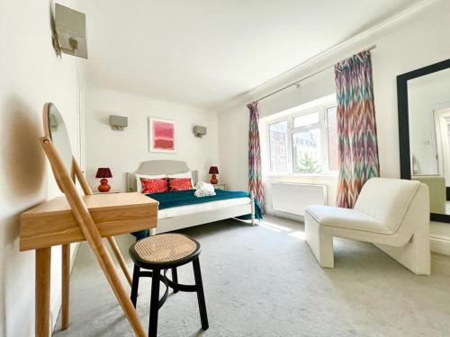 a bedroom with a bed and a chair and a desk at Split Level 2 Bed Apartment- Mayfair in London