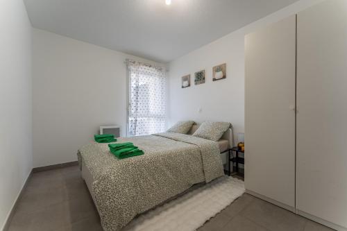 une chambre blanche avec un lit et une fenêtre dans l'établissement L'Arlésien - A 15 min du Parc Naturel Régional de Camargue, à Arles