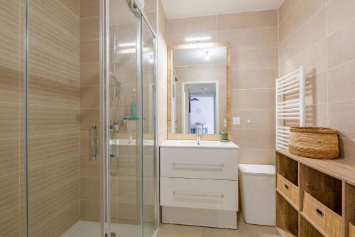 une salle de bain avec un lavabo et une douche en verre dans l'établissement Le Sunny - Appt climatisé avec piscine, à Saint-Raphaël