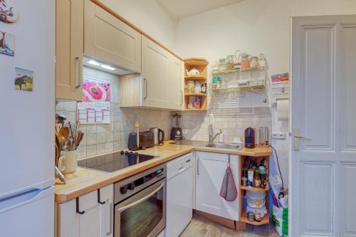 une cuisine avec des armoires blanches et un réfrigérateur blanc dans l'établissement Snow Tram - Proche piste et thermes, à Saint-Gervais-les-Bains