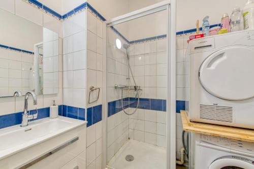 une salle de bain avec douche et lavabo et une machine à laver dans l'établissement Snow Tram - Proche piste et thermes, à Saint-Gervais-les-Bains