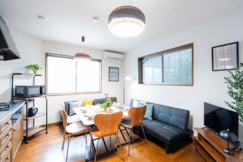 a living room with a table and a couch at LN23 神戸三宮駅と新神戸駅から交通至便3LDK憩House in Kobe