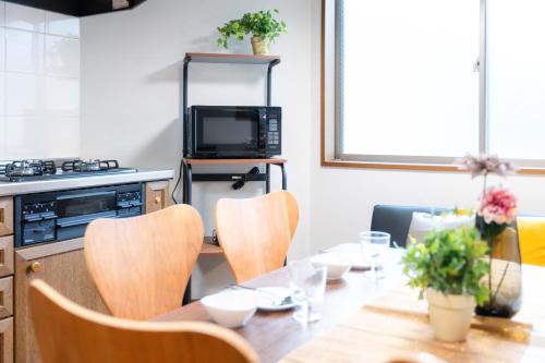 a kitchen with a table with chairs and a microwave at LN23 神戸三宮駅と新神戸駅から交通至便3LDK憩House in Kobe