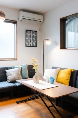 a living room with a couch and a table at LN23 神戸三宮駅と新神戸駅から交通至便3LDK憩House in Kobe