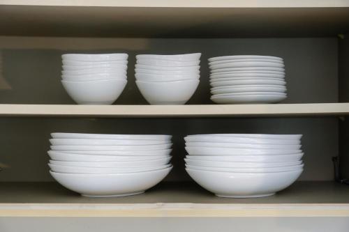 a group of white bowls on a shelf at LN23 神戸三宮駅と新神戸駅から交通至便3LDK憩House in Kobe