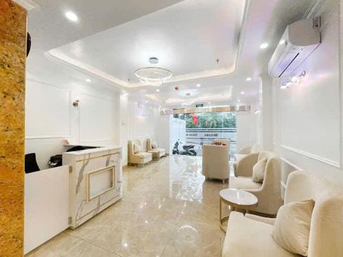 a living room with white furniture and a table at Chemi Hanoi Airport Hotel in Sóc Sơn