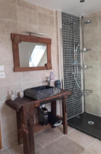 La salle de bains est pourvue d'un lavabo en bois et d'une douche. dans l'établissement Maison de montagne, à La Cabanasse