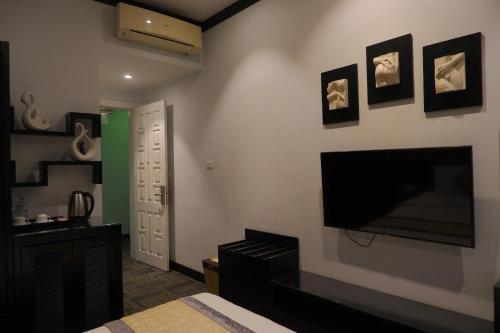 a living room with a tv and a bedroom at Tuong Vi Hotel in Hai Phong