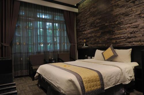 a hotel room with a bed and a brick wall at Tuong Vi Hotel in Hai Phong