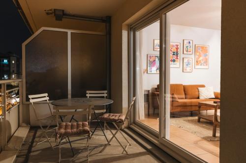 une chambre avec une table et des chaises ainsi qu'un salon dans l'établissement Pisana House - Appartement de charme tout confort, à Annemasse
