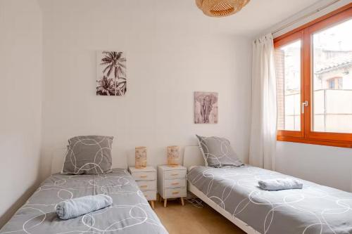 une chambre avec deux lits jumeaux et une fenêtre dans l'établissement Les Arènes, 30m des Arènes, Balcon, Clim, à Nîmes