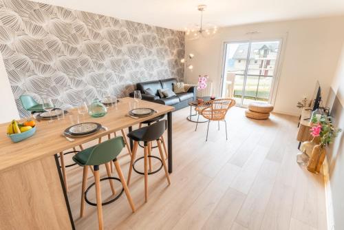 a kitchen and living room with a table and chairs at Elégant Appartement 2 chambres bord de mer par Groom in Ploemeur