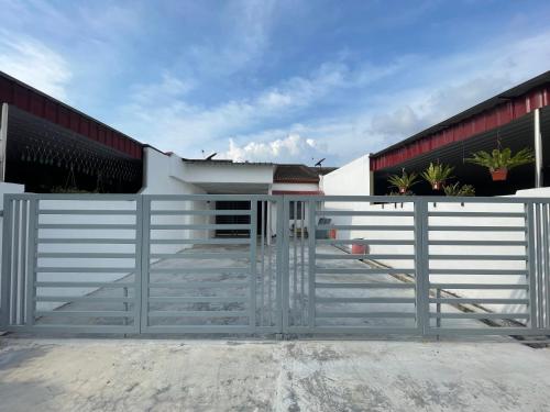 a white fence in front of a house at Cozy10perwira#6pax#Netflix#neariconcity&iconicpoint in Simpang Ampat