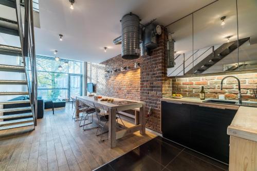 a kitchen with a table and a brick wall at Qbik Loft Aparts in Warsaw