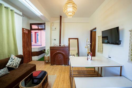 a living room with a couch and a table at Monratino Himadrie -2 mins walk from Mall Road - All rooms have Kanchenjunga Mountain View in Darjeeling