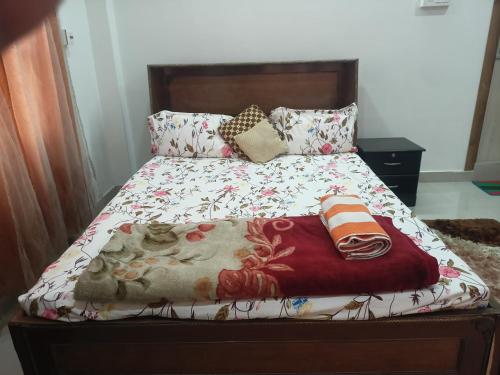 a bedroom with a bed with a floral bedspread and pillows at Luxury Bonafide Villa in Lohārghāt