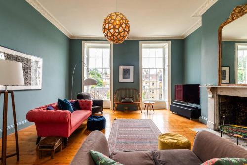 a living room with a couch and a fireplace at Grand Georgian Townhouse with Garden in Bath