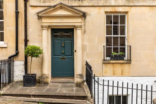 a blue door on the side of a building at Grand Georgian Townhouse with Garden in Bath