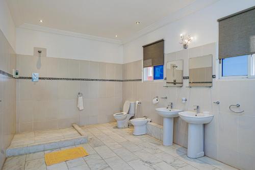 a bathroom with two toilets and two sinks at Ocean Villa Heights in Brufut