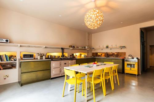 a kitchen with a table and yellow chairs at Grand Georgian Townhouse with Garden in Bath
