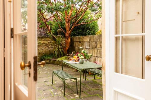 a table with fruit on it in a backyard at Grand Georgian Townhouse with Garden in Bath