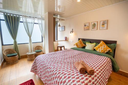 a bedroom with a bed with two towels on it at Monratino Himadrie -2 mins walk from Mall Road - All rooms have Kanchenjunga Mountain View in Darjeeling
