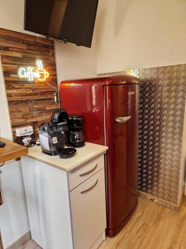 La cuisine est équipée d'un réfrigérateur rouge. dans l'établissement 06 - Très joli 2 pièces neuf climatisé pour 1 à 4 personnes avec 3 lits, vue sur jardin, parking privatif gratuit, grand fourgon possible, tout le linge de maison est fourni, à Razac-sur-lʼIsle