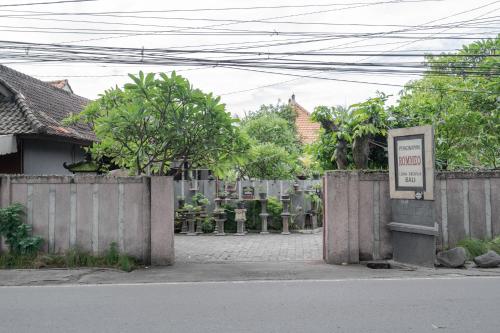 a fence with a sign in front of a cemetery at Rommeo Inn Lovina Mitra RedDoorz in Temukus