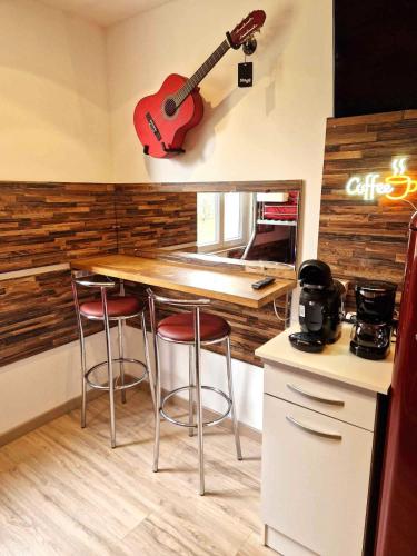 - une cuisine avec un comptoir et une guitare sur le mur dans l'établissement 06 - Très joli 2 pièces neuf climatisé pour 1 à 4 personnes avec 3 lits, vue sur jardin, parking privatif gratuit, grand fourgon possible, tout le linge de maison est fourni, à Razac-sur-lʼIsle