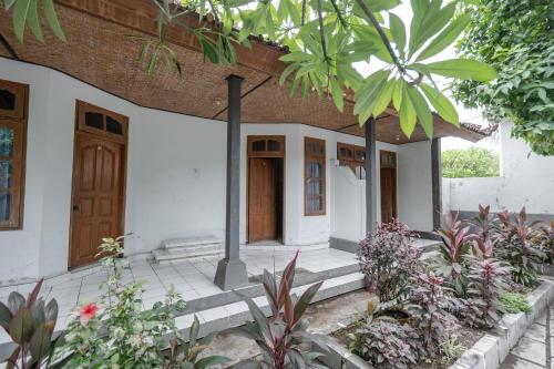 a house with a door and some plants at Rommeo Inn Lovina Mitra RedDoorz in Temukus