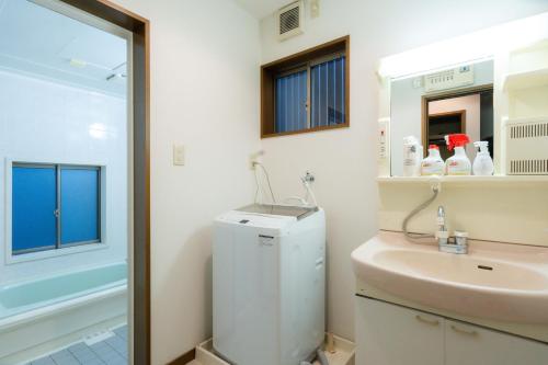 a bathroom with a sink and a toilet and a mirror at LN23 神戸三宮駅と新神戸駅から交通至便3LDK憩House in Kobe