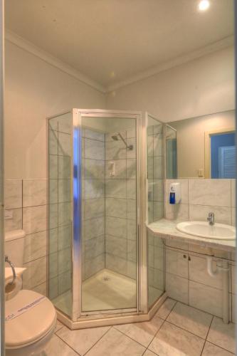 a bathroom with a shower and a toilet and a sink at Port Arthur Motor Inn in Port Arthur