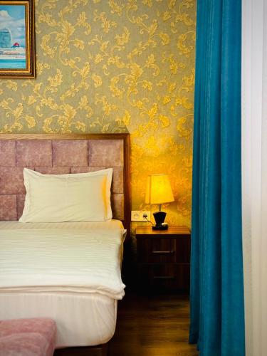 a bedroom with a bed and a table with a lamp at ARK BILLUR HALAL Hotel in Tashkent