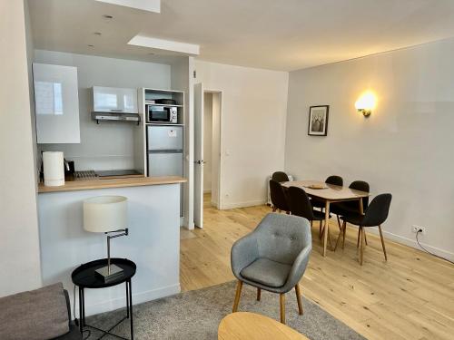 un salon avec une table et des chaises et une cuisine dans l'établissement Surcouf appartements, à Paris