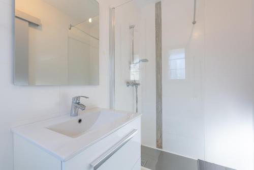 a white bathroom with a sink and a shower at Chalet de Sers in Sers