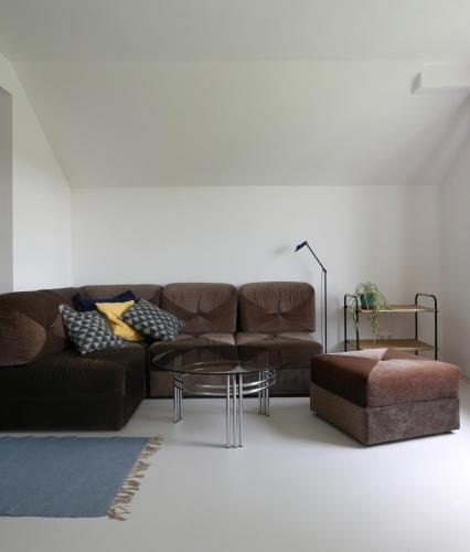 a living room with a brown couch and a coffee table at Unter einem Dach in Raabs an der Thaya