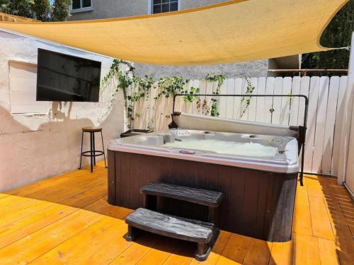 a hot tub on a patio with a tv at 3 bedroom with Hot Tub and Video game console 10 minutes from Rodeo Drive Beverly Hills in Los Angeles