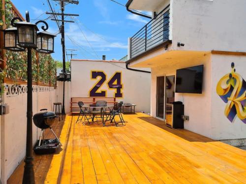a wooden deck with chairs and a television on a building at 3 bedroom with Hot Tub and Video game console 10 minutes from Rodeo Drive Beverly Hills in Los Angeles