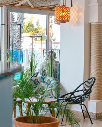 a room with two chairs and a table with plants at Les Bulles de Mer - Hotel & Spa sur la Plage in Saint-Cyprien