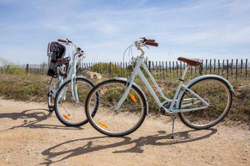 two bikes parked next to each other on a dirt road at Les Bulles de Mer - Hotel & Spa sur la Plage in Saint-Cyprien