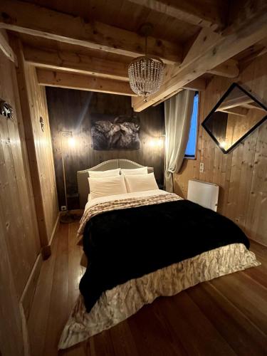 une chambre avec un grand lit dans une pièce aux murs en bois dans l'établissement La Petite Maison, à Gérardmer