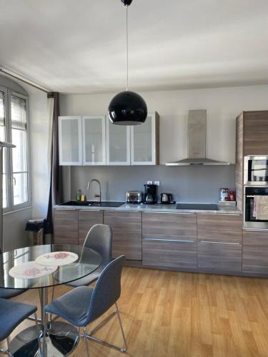 une cuisine avec une table en verre et des chaises dans une pièce dans l'établissement Appartement centre ville Marseille avec parking, à Marseille