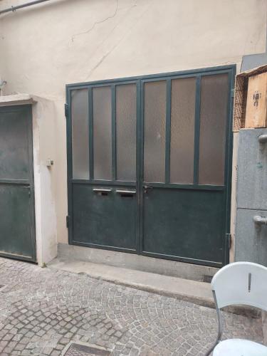 a green garage door with a bench in front of it at Appartamento in centro Tollegno in Tollegno