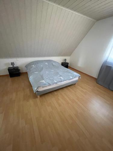 a bed in a room with a wooden floor at Appartement de l angle Im Winkel in Oberbetschdorf