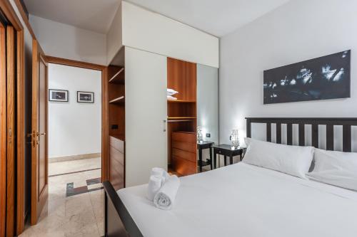 a bedroom with a white bed and a desk at Elegantis Purificazione Suite Apartment in Rome