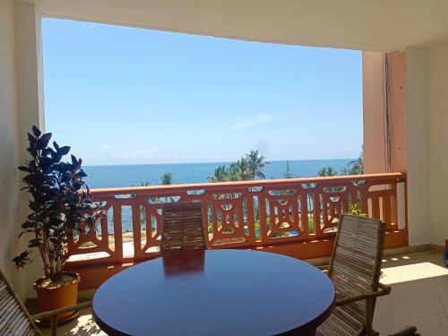 a table and chairs on a balcony with a view of the ocean at Elephant Legacy Staycations in Mombasa