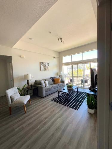 a living room with a couch and a tv at Resort-Inspired Bliss- Modern & Cozy Apartment in Salt Lake City