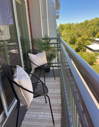 a balcony with two chairs and a plant at Resort-Inspired Bliss- Modern & Cozy Apartment in Salt Lake City